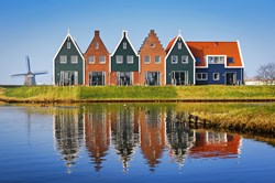 Farbige Häuser des Meeresparks in Volendam spiegeln sich im Wasser, Niederlande