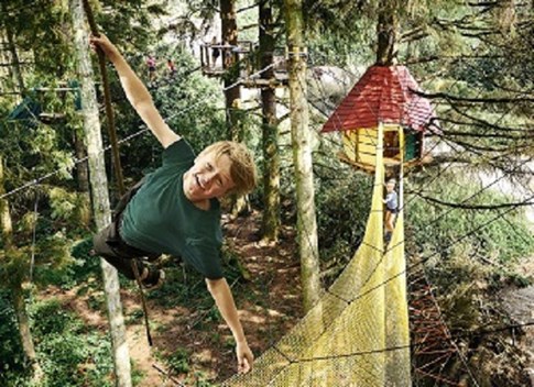 Ein großer Junge hängt in einem Kletterseil im WOW PARK