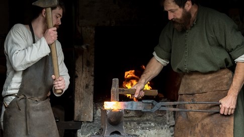Zwei Schmiede aus dem Mittelalter bei der Arbeit