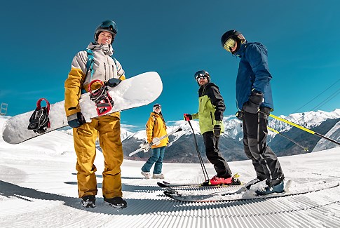 Vier Skifahrer im Schnee an einem sonnigen Tag