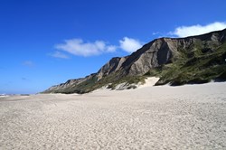 Blick entlang des Strandes vor den Klippen am bekannten Leuchtturm Bovbjerg Fyr an der dänischen Nordseeküste
