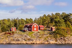 Rote Ferienhäuser auf einer Felseninsel in Südschweden