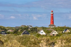 Roter Leuchtturm zwischen den Häusern des Dorfes Schiermonnikoog
