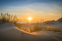 Weg zwischen den Dünen führt zum Strand bei Sonnenuntergang