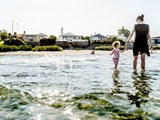 Eine Mutter und ihr Kind genießen einen Sommertag im flachen Strandwasser auf Fünen