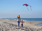 Zwei kleine Kinder lassen einen Drachen am Strand steigen