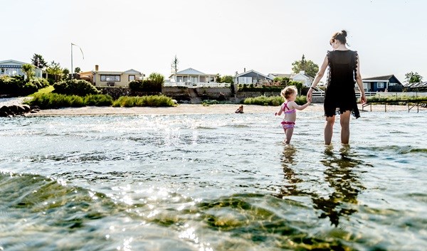 Eine Mutter und ihr Kind genießen einen Sommertag im flachen Strandwasser auf Fünen