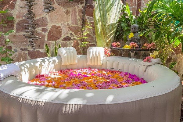 Whirlpool im Ferienhaus mit bunten Blütenblätern