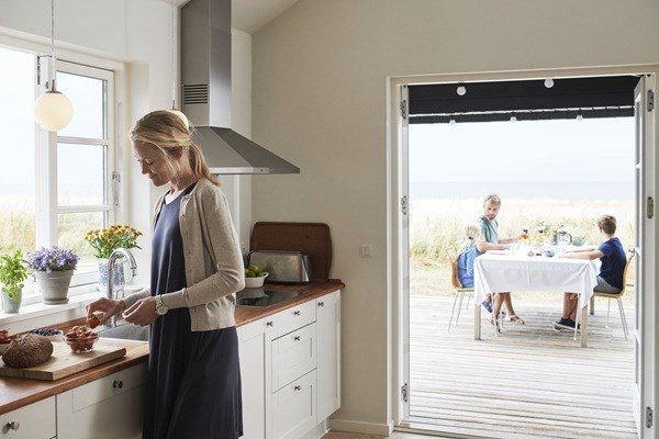 Eine Familie frühstückt auf der Terrasse ihres Ferienhauses in Dänemark