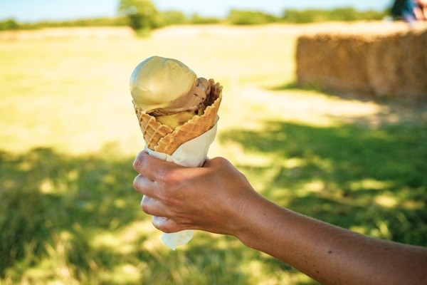 Hand hält eine Eiswaffel mit Kugeln