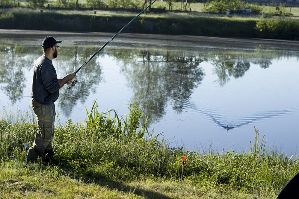 Angler mit einer Angelrute am Wasser in Dänemark