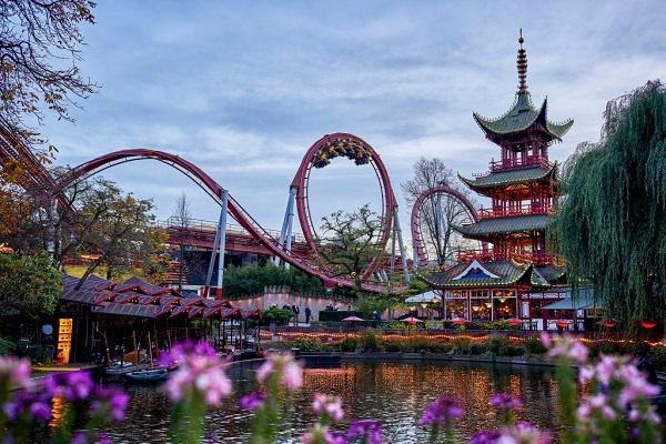 Der Achterbahn „Dämon“ und der Japanische Turm im Tivoli am Abend