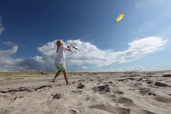 Ein Mädchen lässt im Sommer am Strand einen Drachen steigen