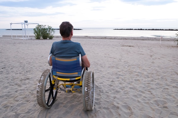 Ein Mann im Strandrollstuhl am Strand