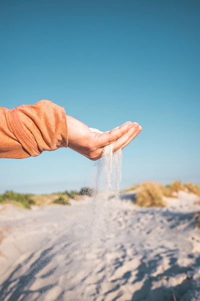 Eine Hand voller Sand am Dueodde-Strand auf Bornholm