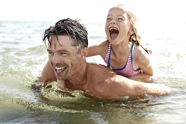 Vater spielt mit Kind im Wasser auf Lolland