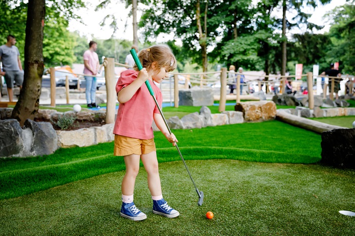 Kleinkind beim Minigolf spielen
