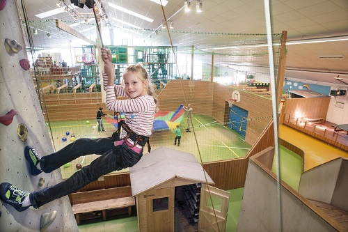 Mädchen in Indoorspielhalle an Kletterwand