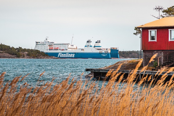 Eine Finnlines-Fähre vor der Kulisse eines traditionellen roten Schwedenhauses