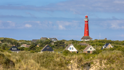 Roter Leuchtturm zwischen den Häusern des Dorfes Schiermonnikoog