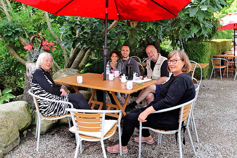 Eine Familie mit Großeltern macht eine Pause im Café Klokkeblomst in Birkegårdens Haver
