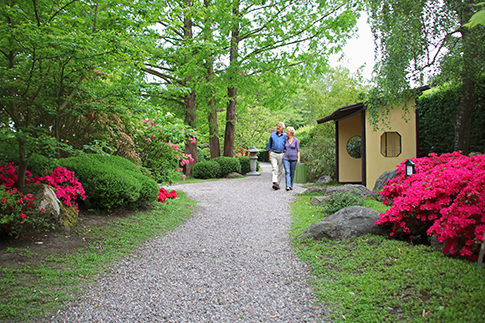 Ein älteres Paar spaziert durch den Japanischen Garten in Birkegårdens Haver