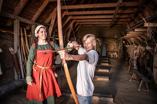 Ein Kind versucht sich im Bogenschießen im Bork Vikingehavn