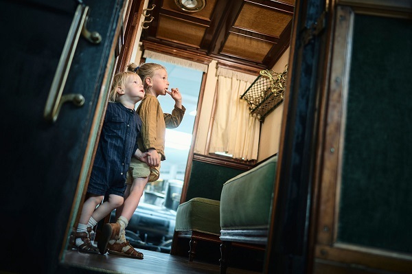 Zwei Kinder entdecken ein historisches Zugabteil im Dänischen Eisenbahnmuseum