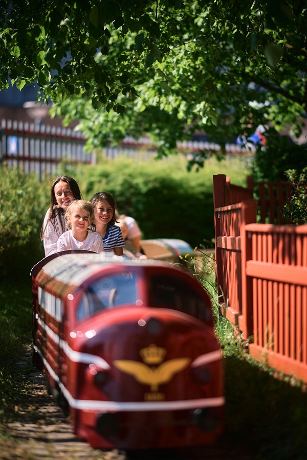 Eine Familie fährt mit der Minibahn im Dänischen Eisenbahnmuseum