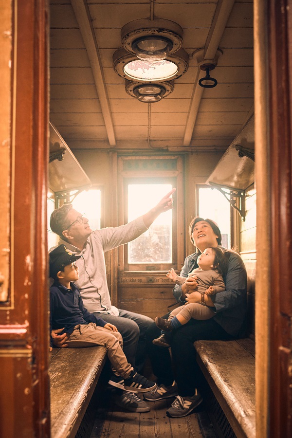 Eine Familie im historischen Zugabteil im Dänischen Eisenbahnmuseum