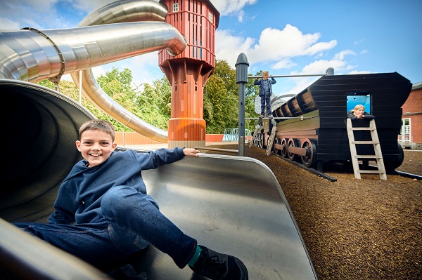 Ein Junge spielt im Freien auf dem Spielplatz des Dänischen Eisenbahnmuseums