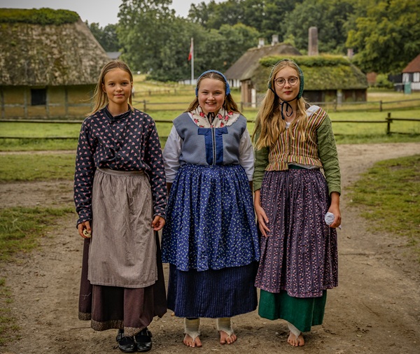 Drei Mädchen in typischer Kleidung der Zeit im Museum Hjerl Hede