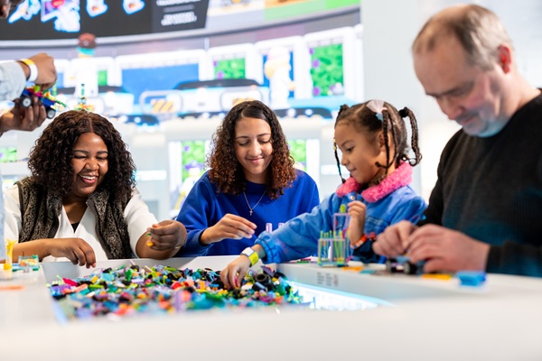 Eine Familie baut mit LEGO® Steinen im LEGO® House