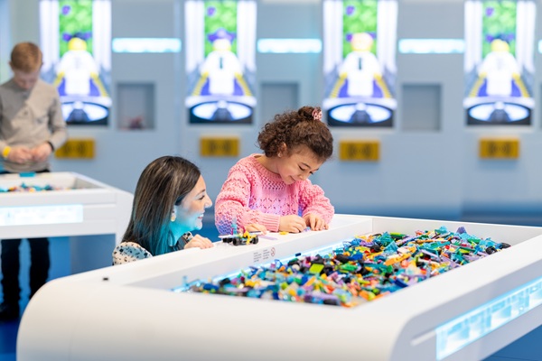 Ein kleines Mädchen baut zusammen mit ihrer Mutter mit LEGO® Steinen im LEGO® House
