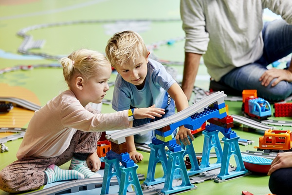 Ein Junge und ein Mädchen spielen mit einem DUPLO® Zug im LEGO® House