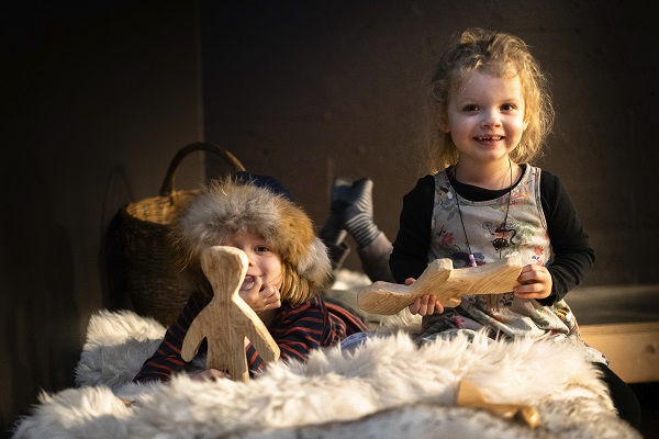 Zwei Kinder sitzen im Kinderdorf des Wikingerschiffsmuseums in Roskilde